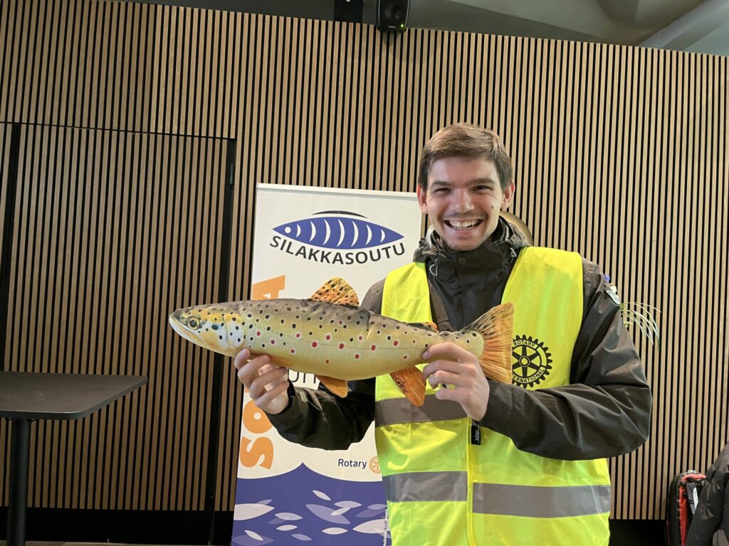 iloinen poika turvaliivissä pitelee kalanmuotoista pehmolelua